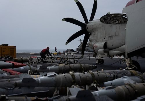 A sailor handles munitions on the flight deck of the USS George Washington in the Arabian Sea, Se...